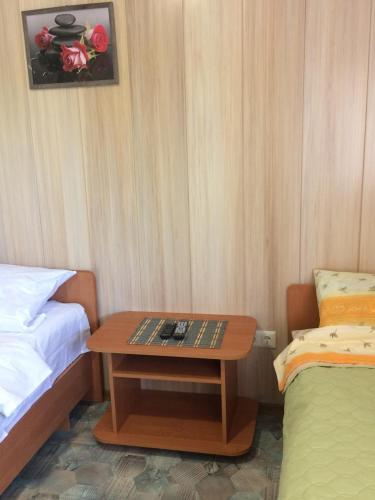 ein kleines Zimmer mit einem Tisch neben einem Bett in der Unterkunft Дом семейного отдыха in Karolino-Buhas