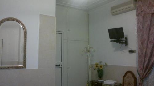 ein Bad mit einem Spiegel und einem TV an der Wand in der Unterkunft Hotel Stadler 2 in Rom