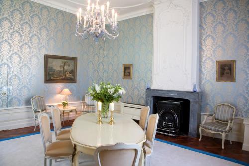 a dining room with a table and chairs and a chandelier at Stadspaleis Hotel & Restaurant OldRuitenborgh in Vollenhove