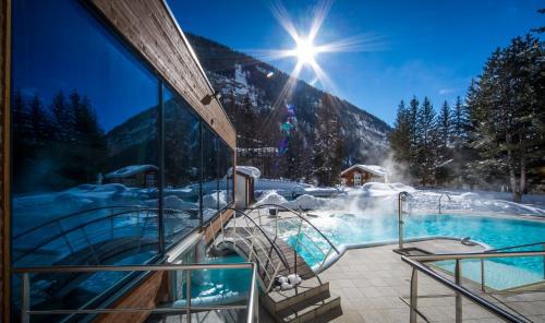 a resort with a hot tub in the snow at Le Bristol Leukerbad in Leukerbad