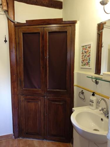 - une salle de bains avec une porte en bois à côté d'un lavabo dans l'établissement Centro con encanto., à Valence