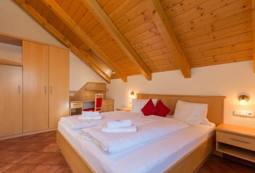 a large bed in a room with wooden ceilings at Villa Marienhof in Annenheim
