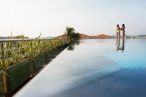 two people are standing on a bridge over a body of water at Villa Romana Fréjus in Fréjus