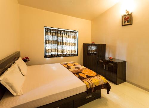 una camera con un grande letto e una finestra di Aneesha Villa a Mahabaleshwar
