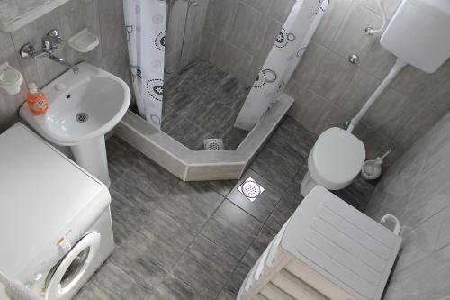 a bathroom with a shower and a toilet and a sink at Olja apartments in Virpazar