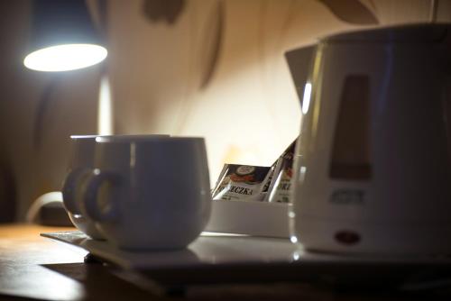 a coffee cup sitting on a table next to a toaster at Hotel Biathlon Sport & Spa in Szklarska Poręba
