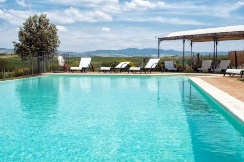 a swimming pool with chairs and a gazebo at Agriturismo San Marcello in Castiglione dʼOrcia
