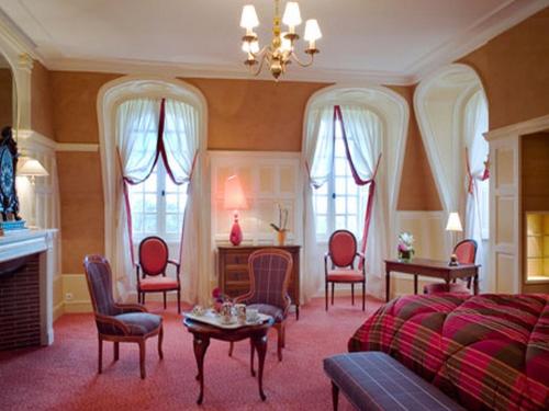 Una sala de estar con una cama, una mesa y sillas. en Château de Beaulieu et Magnolia Spa, The Originals Relais, en Joué-lès-Tours