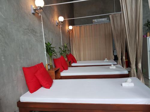 two beds in a room with red pillows at The Now Hotel - SHA Extra Plus in Jomtien Beach