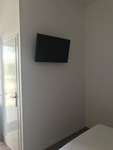 a flat screen tv hanging on a wall in a bedroom at Sea View Room Macolic in Rab
