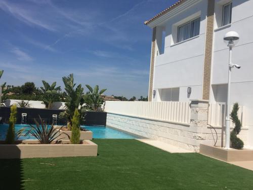 a swimming pool in the backyard of a house at Apartamentos La Laguna I Luxury Apartments in Guardamar del Segura