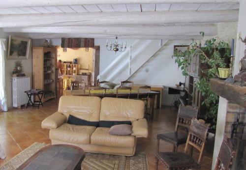 a living room with a couch and a table at Gîte Aux Tournesols in Malaucène