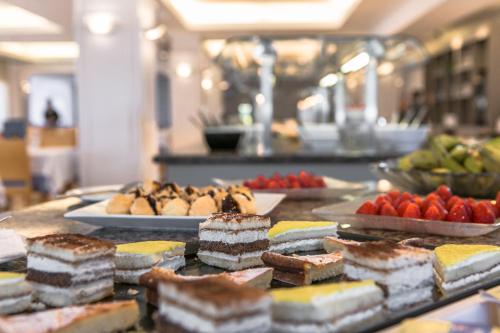 un buffet con pasteles y otros alimentos en una mesa en RVHotels Nieves Mar, en L'Escala