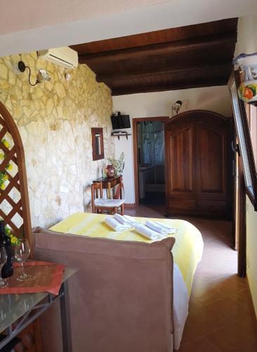 a bedroom with a bed and a stone wall at La Finestra sulle Eolie in Reitano