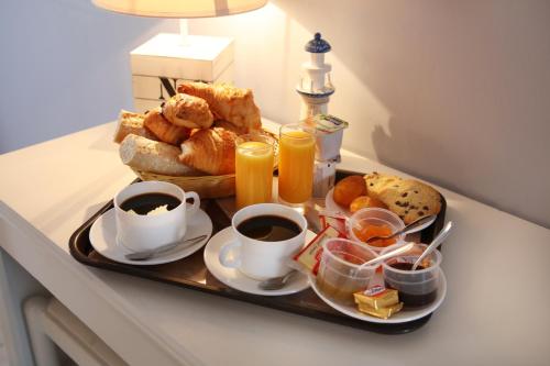 a tray of breakfast foods and coffee on a table at Logis Hotel Le Nuage in La Bussière