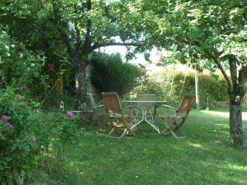 a picnic table and chairs under a tree in a yard at maison La Marche in Cugand