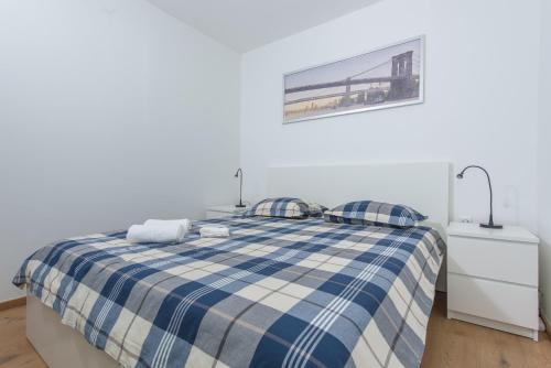 Beach Apartment Marina في مارينا: غرفة نوم بسرير منقوش ازرق وابيض