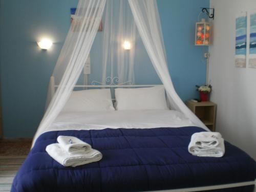 1 dormitorio con 1 cama con toallas en Sunrise Flora, en Agia Marina Aegina