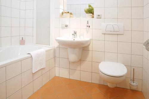 a bathroom with a toilet and a sink and a tub at Hotel Leonardo in Český Krumlov