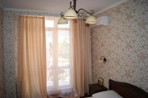 ゲレンジークにあるApartment on Turisticheskayaの窓付きのベッドルーム1室、カーテン付きのベッド1台が備わります。