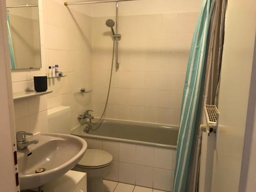 a bathroom with a sink and a toilet and a bath tub at Apartment Hollergrund in Bremen