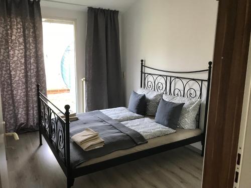 布萊梅的住宿－Apartment Hollergrund，一间卧室配有带枕头的黑色床和窗户。