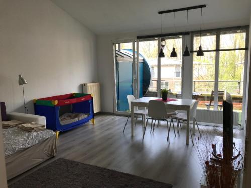 ein Wohnzimmer mit einem Tisch und Stühlen sowie ein Schlafzimmer in der Unterkunft Apartment Hollergrund in Bremen