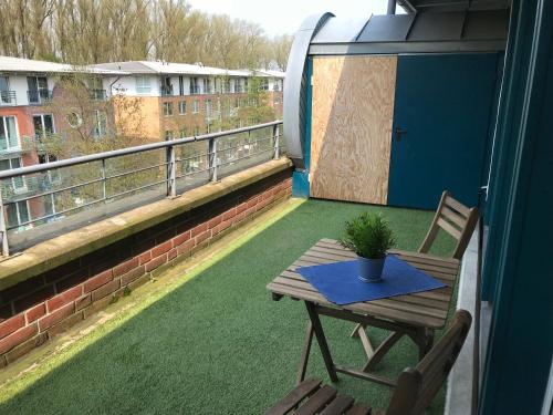 einen Balkon mit einem Tisch und einer Topfpflanze darauf in der Unterkunft Apartment Hollergrund in Bremen