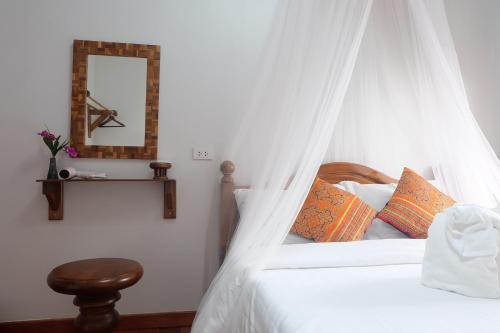 a bedroom with a bed with a mosquito net at Aphilapa Residence in Chiang Mai