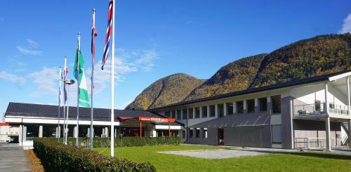 a building with flags in front of a mountain at Blix Hotel in Vikøyri