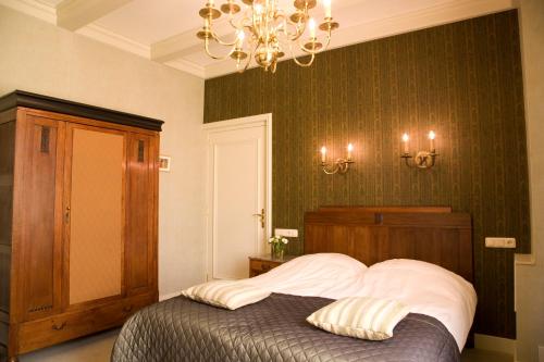 a bedroom with a bed and a chandelier at Stadspaleis Hotel & Restaurant OldRuitenborgh in Vollenhove