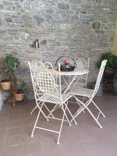 a table and two chairs sitting next to a stone wall at La casa di Marty B&B in Berceto