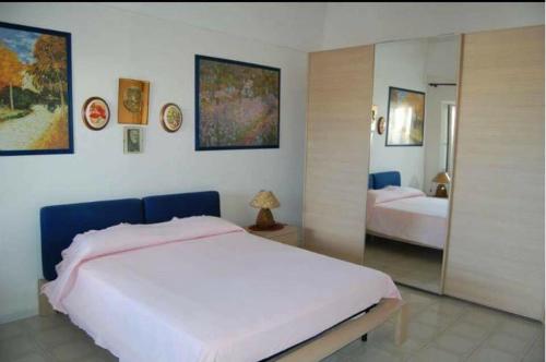 a bedroom with a large white bed and a mirror at PonzaSmeralda Le Forna in Ponza