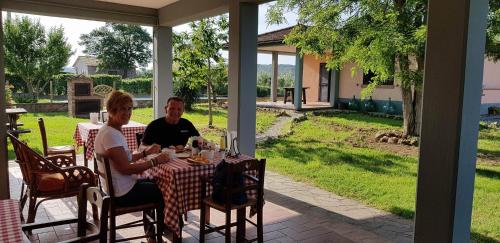 a man and woman sitting at a table on a patio at Agriturismo La Talpa in Marsiliana