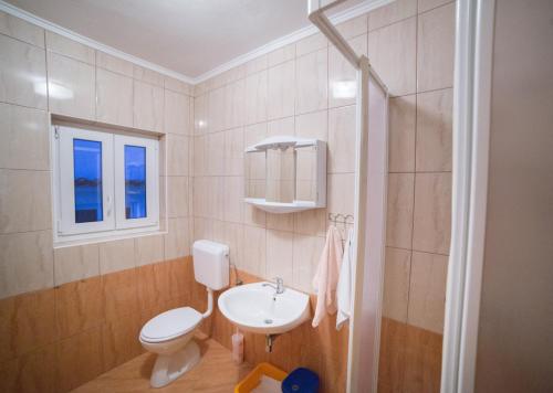 a bathroom with a toilet and a sink at Šanić Apartments 518 in Lopar