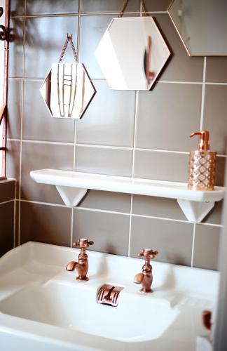 a bathroom with two faucets and a sink at equihome in Écommoy