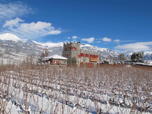 a building in the middle of a snow covered field at Castel de Daval in Sierre