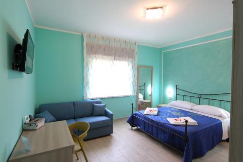 een blauwe slaapkamer met een bed en een bank bij B&b VerdeMare Camerota in Camerota