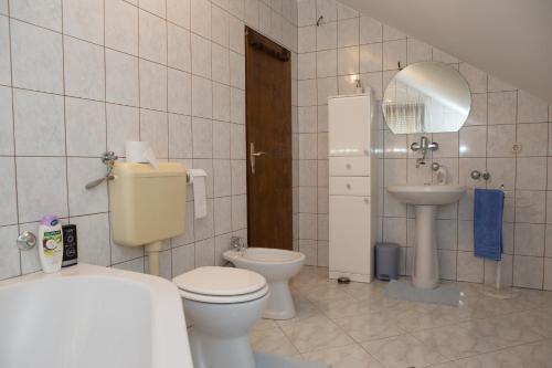 a bathroom with a toilet and a sink and a mirror at Apartman Dubravčić in Otočac