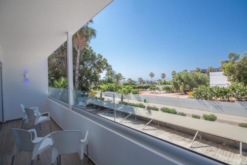 a balcony with chairs and a view of a street at Stratovarius Nissi Rooms in Ayia Napa