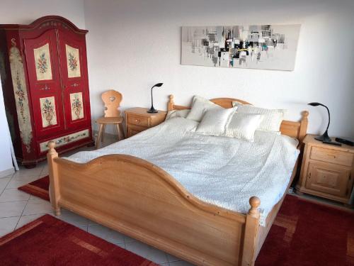 a bedroom with a wooden bed and a red door at Rosenalm Penthouse 147 in Scheidegg