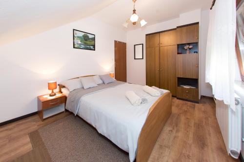 a bedroom with a large bed and a wooden cabinet at Apartman Dubravčić in Otočac