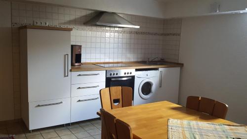 a kitchen with a table and a kitchen with a washing machine at live in the mkk in Hasselroth