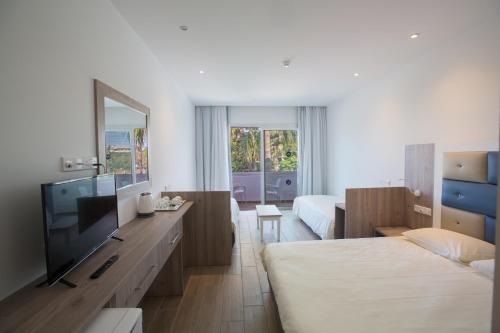 een hotelkamer met 2 bedden en een flatscreen-tv bij Stratovarius Nissi Rooms in Ayia Napa