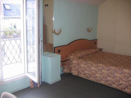 a hotel room with a bed and a window at Hotel Ferney République in Paris