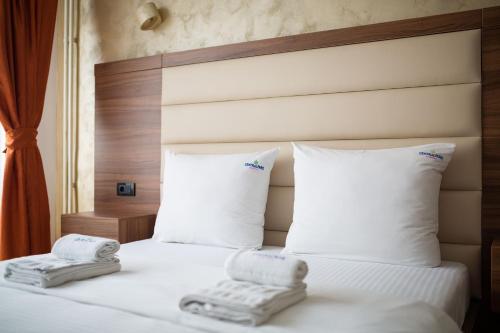 a hotel room with a bed with towels on it at Central Park Apartments in Belgrade