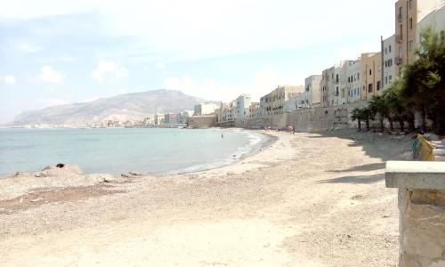 a view of a beach with buildings and the ocean at Appartamento tra mare e storia in Trapani