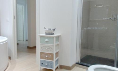 a bathroom with a glass shower and a white cabinet at Appartamento tra mare e storia in Trapani
