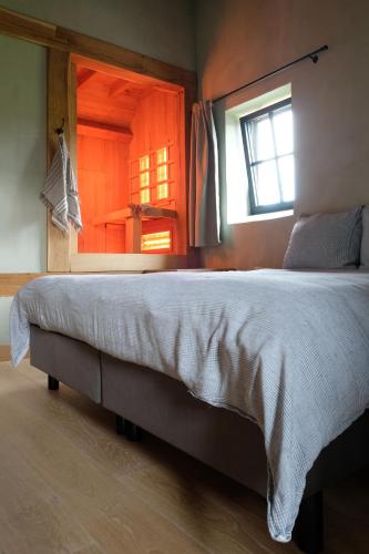 a large bed in a room with a window at B&B de ZIL in Herselt
