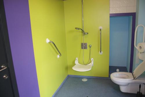 a bathroom with a toilet and a green wall at Antwerp City Hostel in Antwerp
